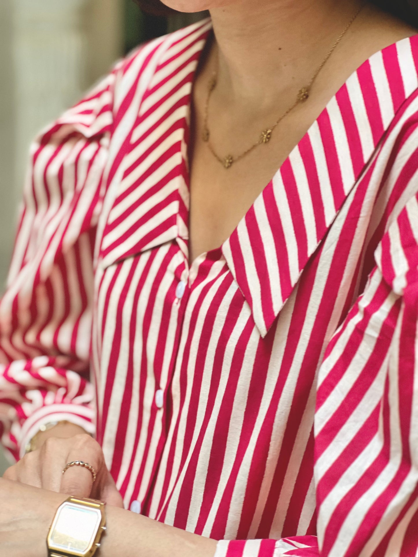Red and white striped shirt worn by a person, with a focus on the neckline and sleeves.