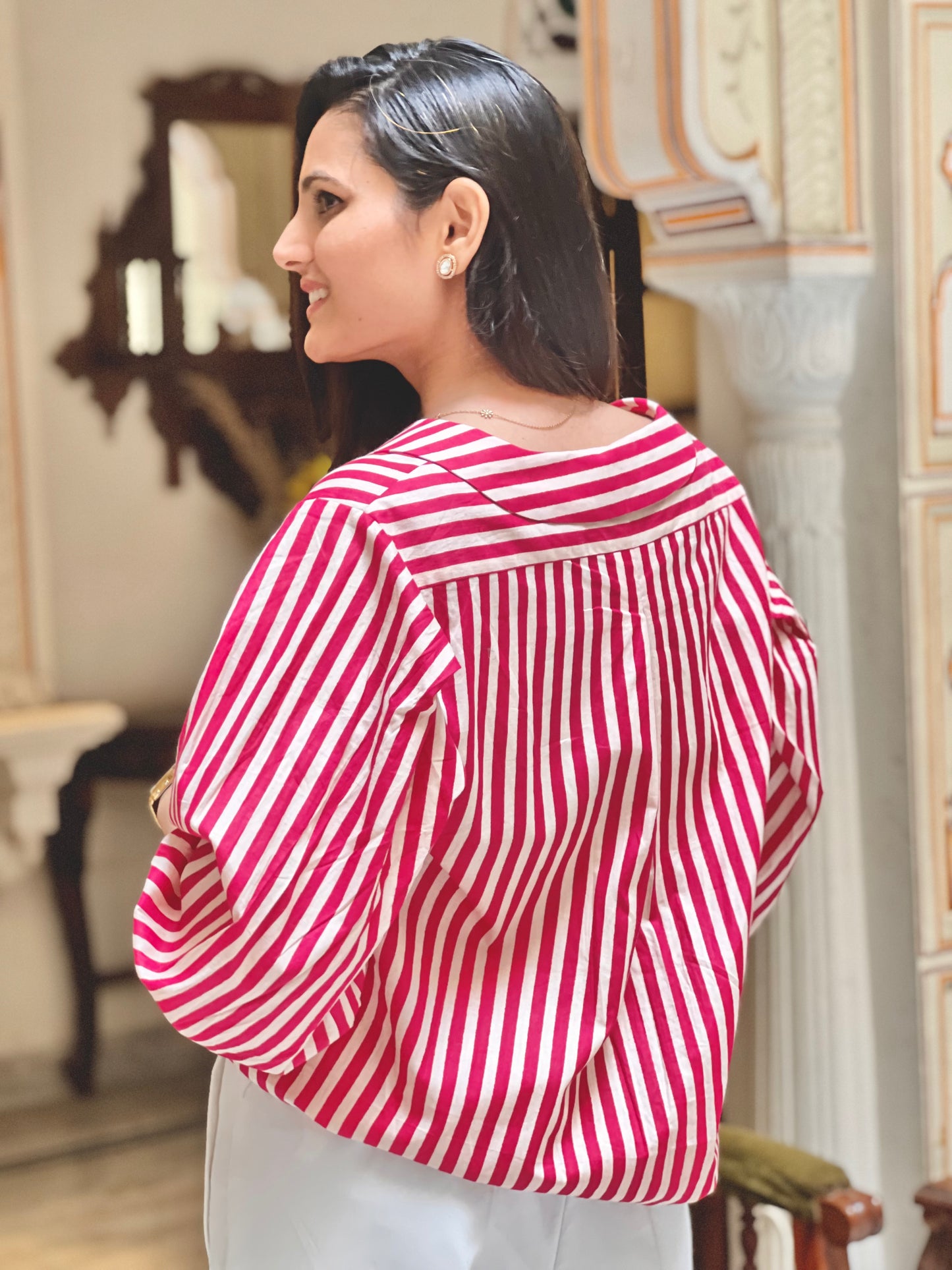 Woman wearing a red and white striped blouse in an indoor setting
