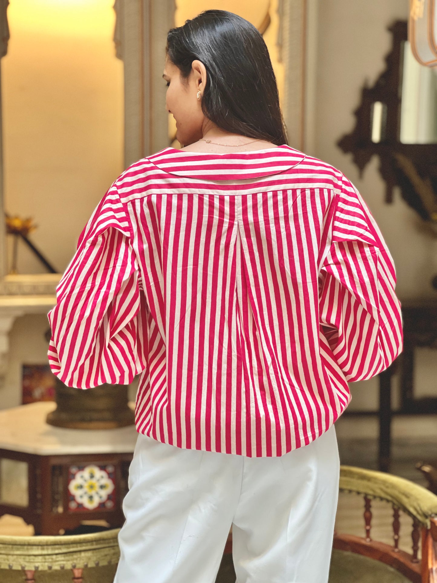Person wearing a red and white striped shirt in an indoor setting