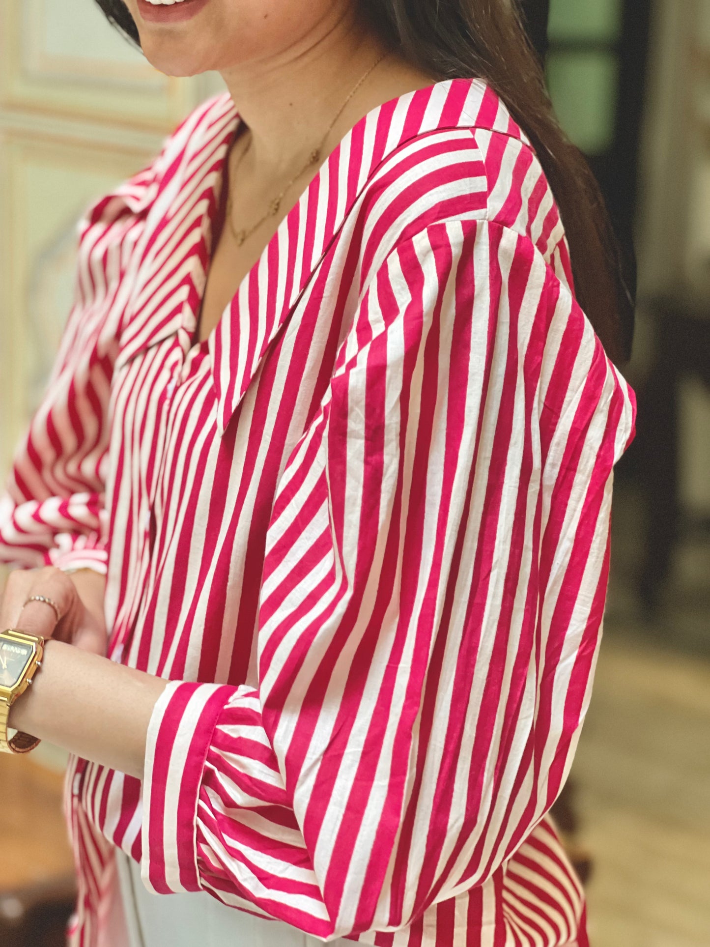 Person wearing a red and white striped shirt with a blurred background