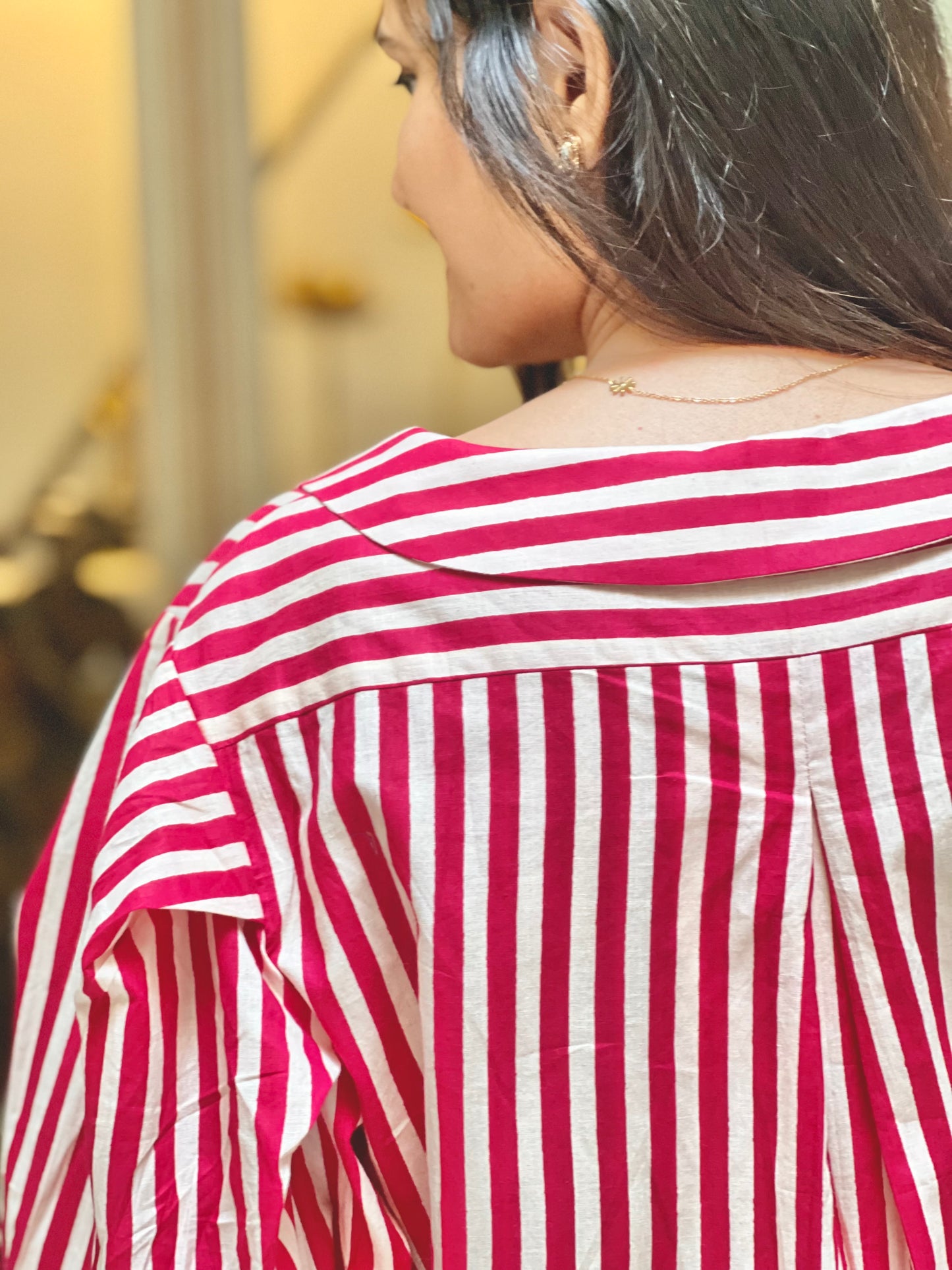 Red and white striped shirt worn by a person with a blurred background