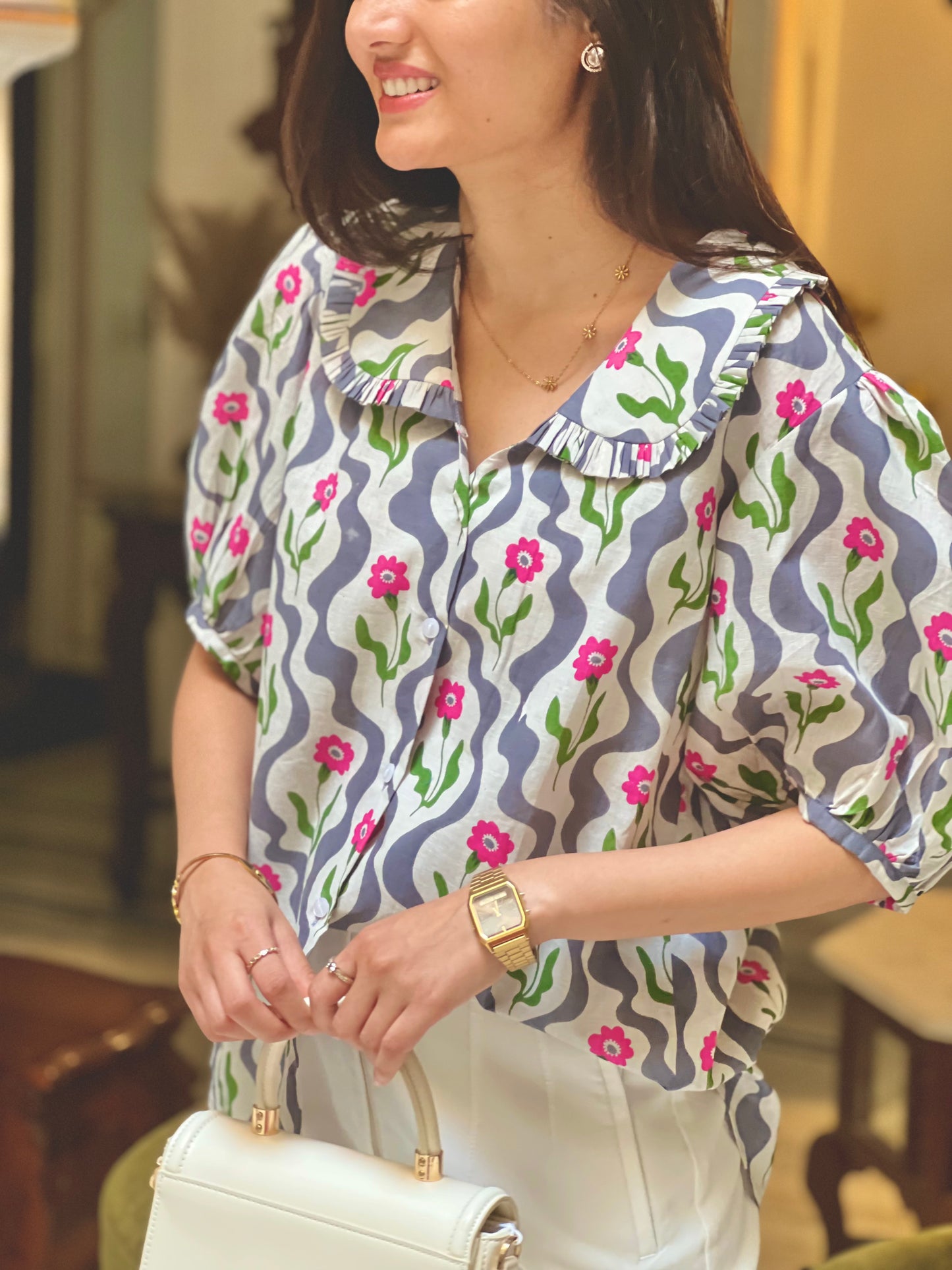 Woman wearing a patterned blouse with floral design indoors