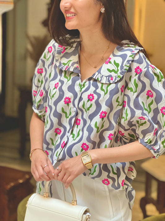 Woman wearing a patterned blouse with floral design indoors