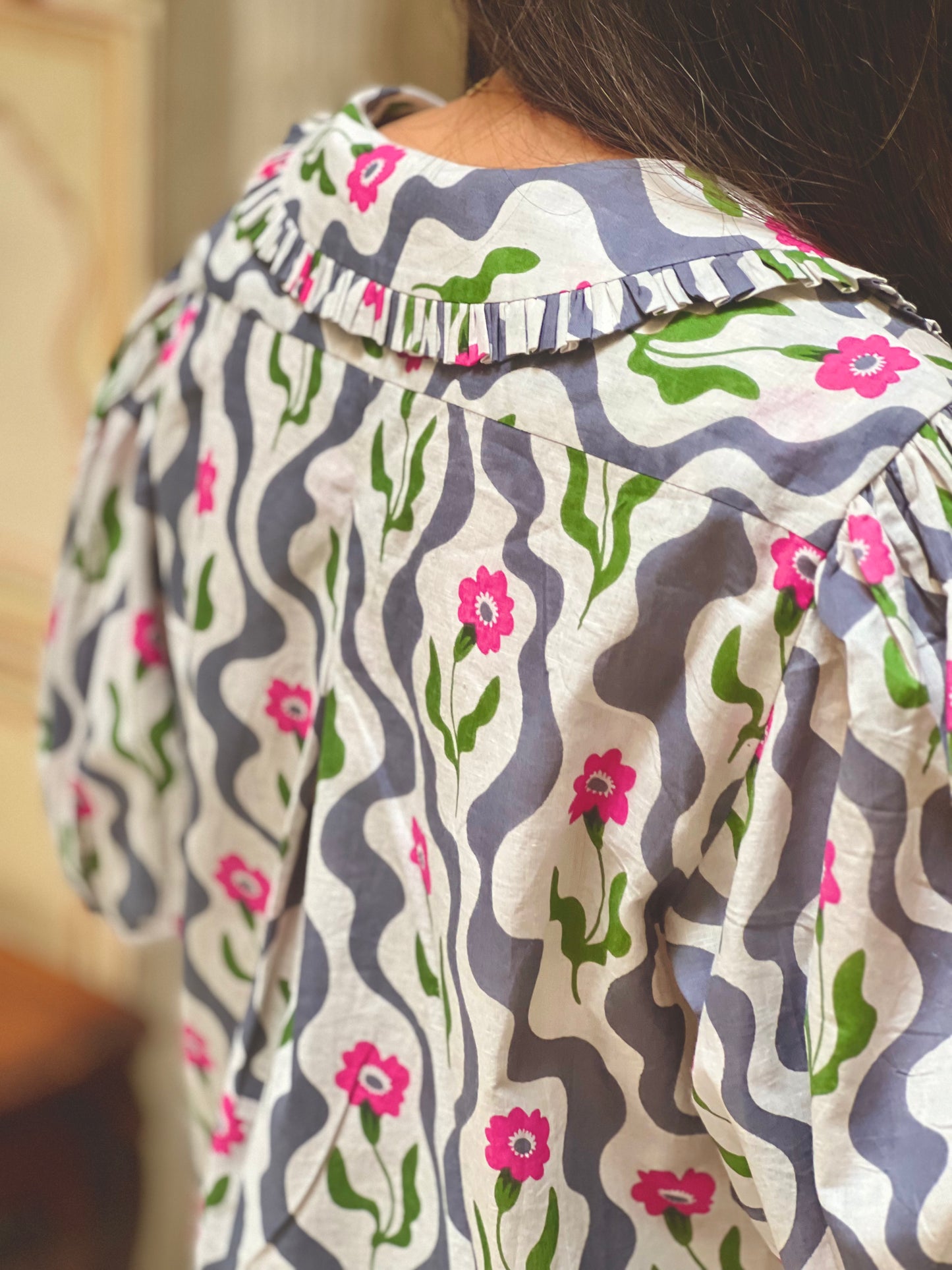 Close-up of a patterned shirt with floral designs on a blurred background