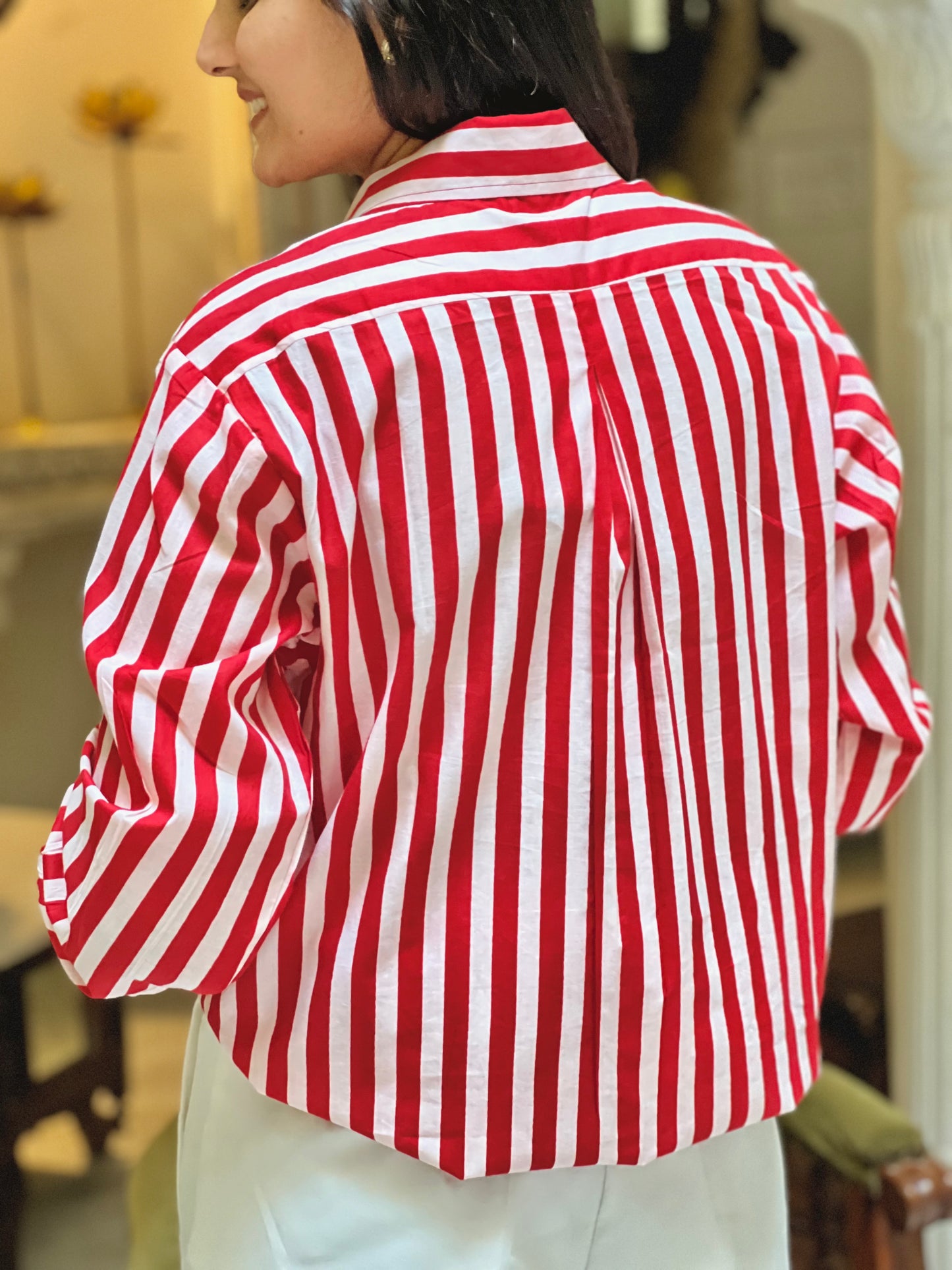 Person wearing a red and white striped shirt indoors