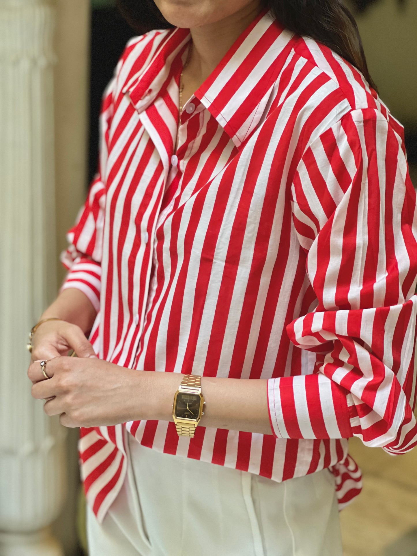 Person wearing a red and white striped shirt with a blurred background