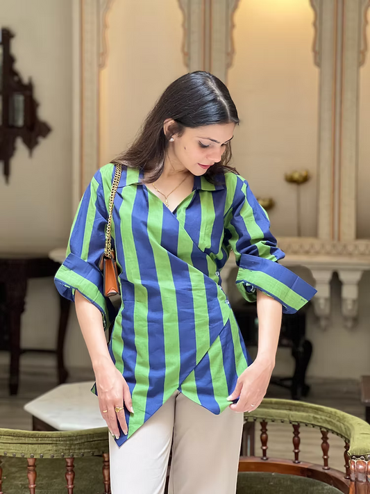 Woman wearing a blue and green striped shirt in an elegant room.