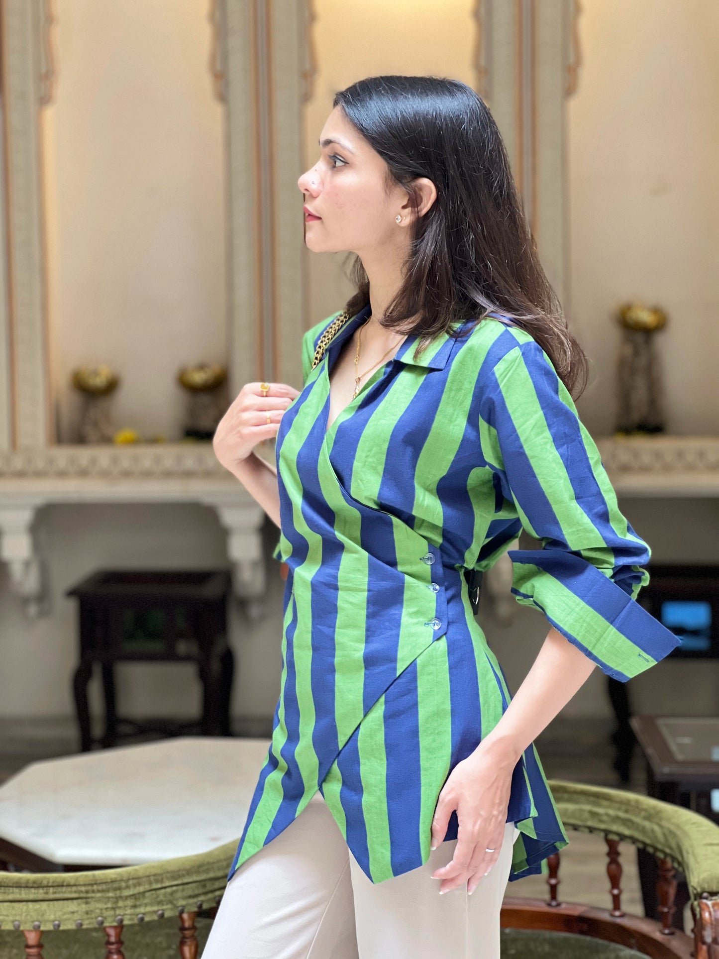 Woman wearing a blue and green striped shirt in an indoor setting