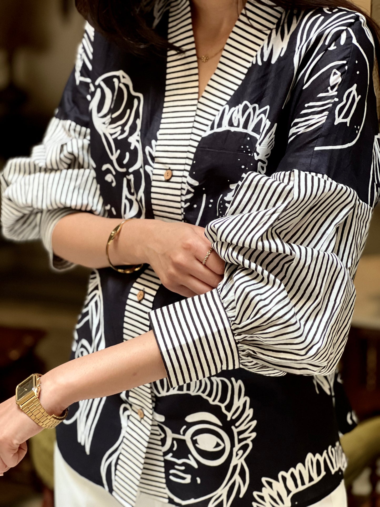 Person wearing a black and white patterned outfit with a blurred background