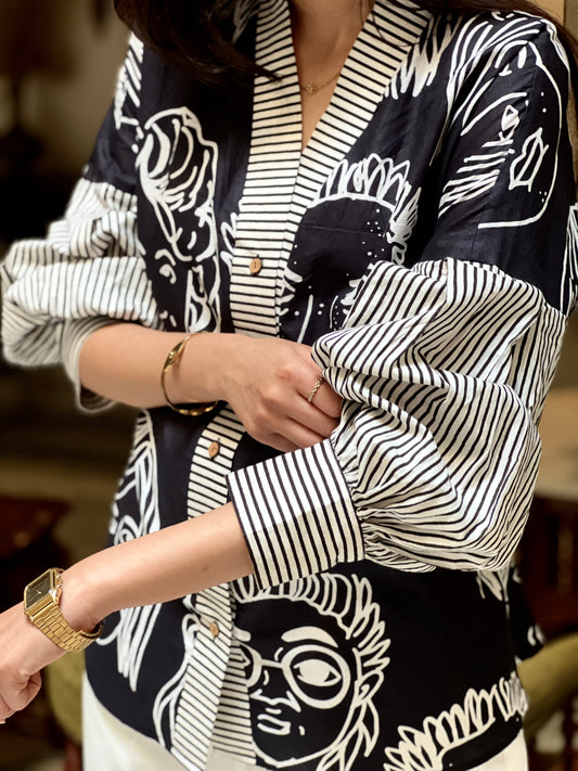 Person wearing a black and white patterned outfit with a blurred background