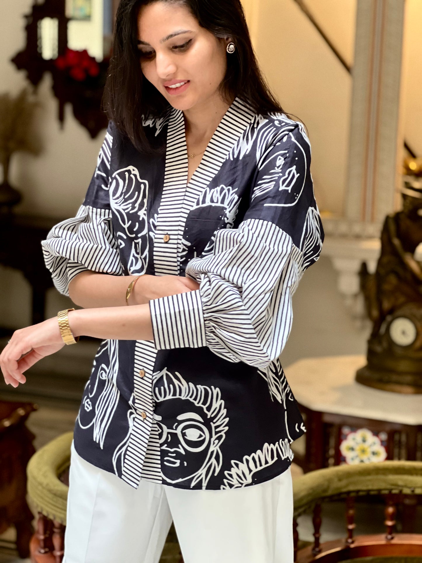 Woman wearing a black and white patterned blouse in an indoor setting