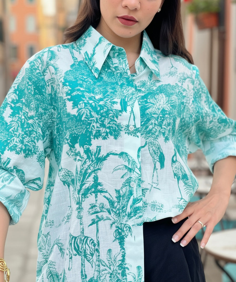 Woman wearing a turquoise floral patterned shirt with a blurred background