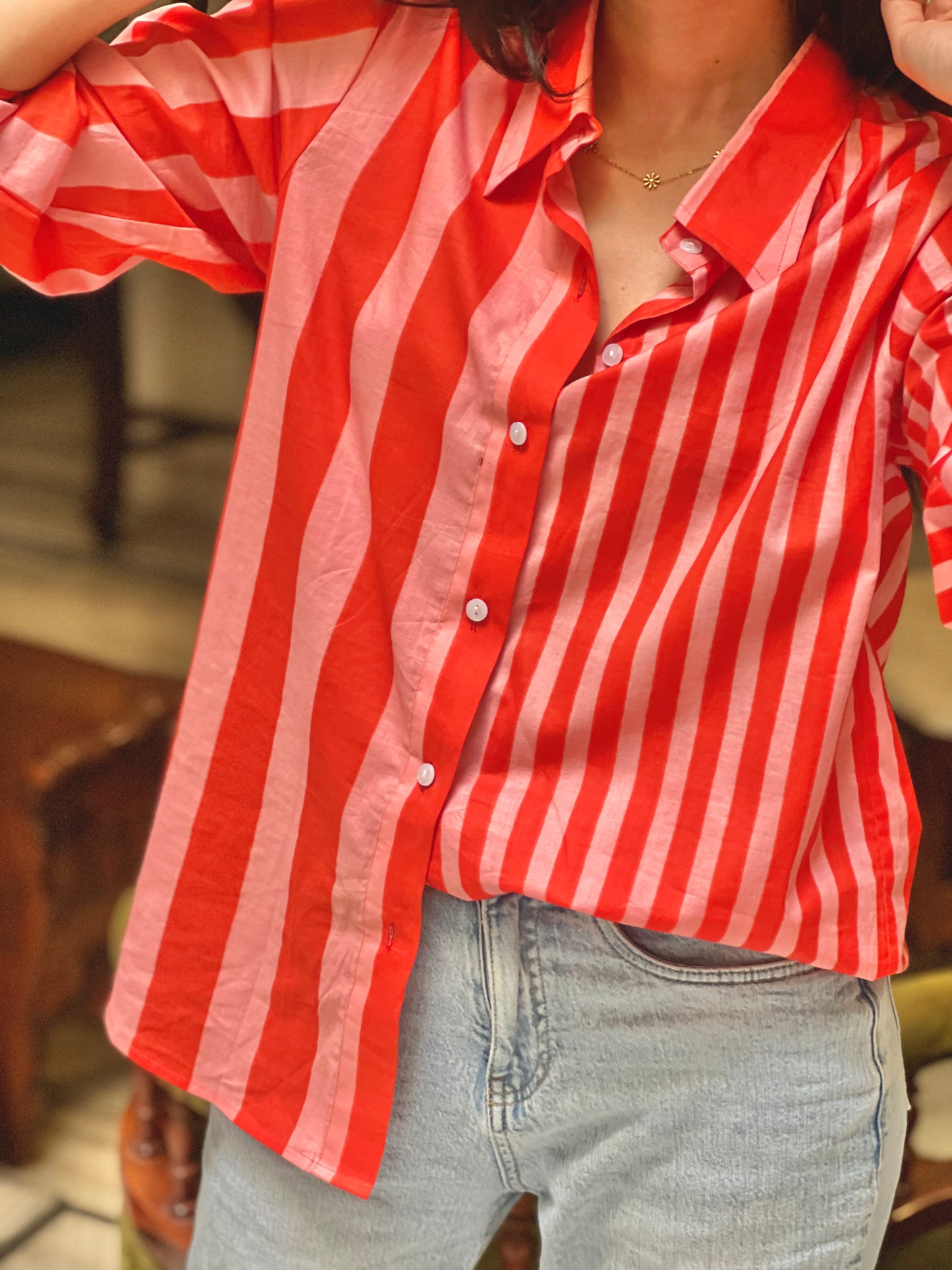 Person wearing a red and white striped shirt with a blurred background