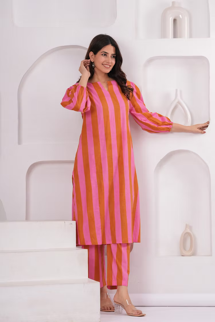 Woman wearing a pink and orange striped outfit against a white background