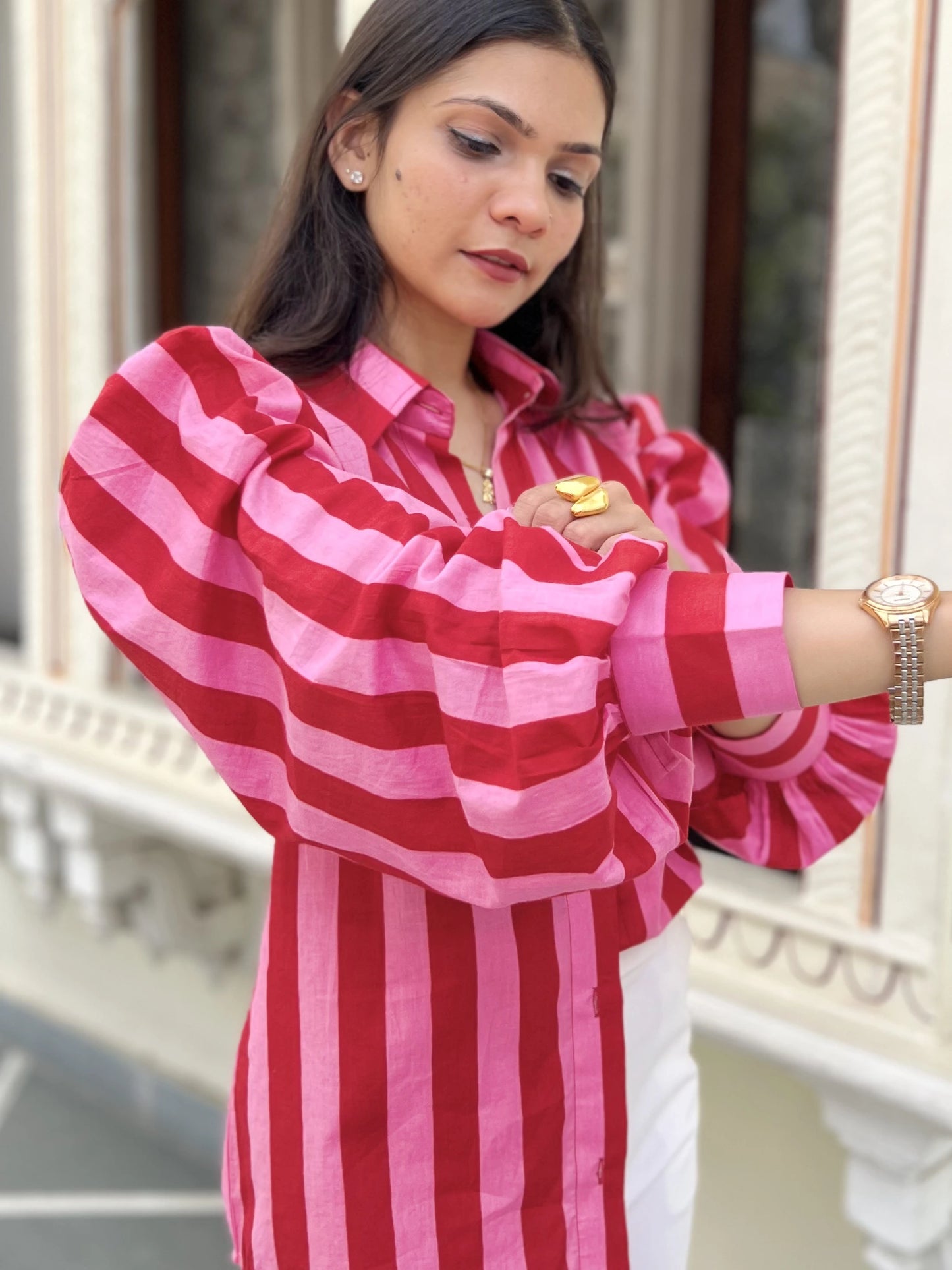 Woman wearing a red and pink striped dress with a blurred background