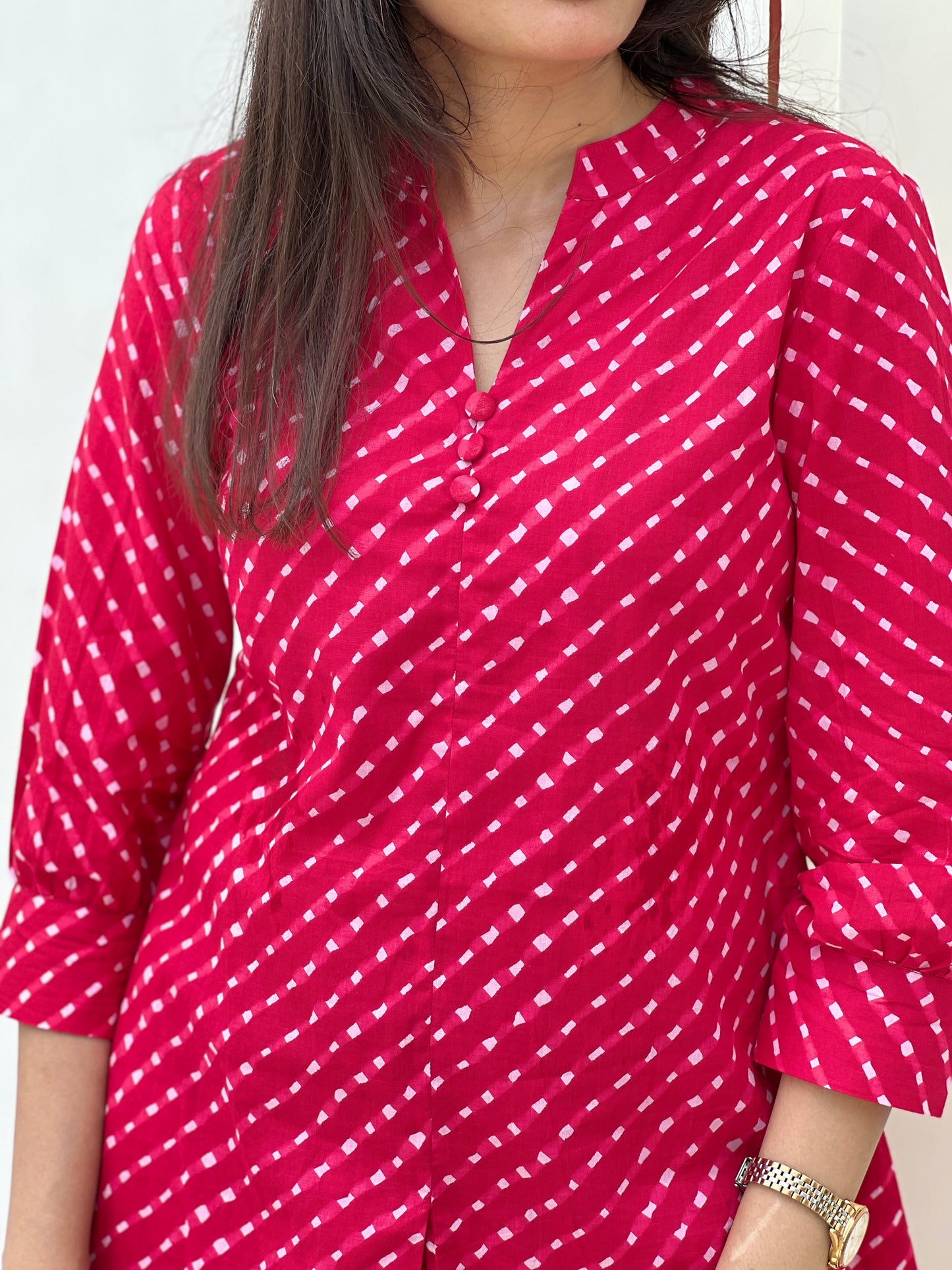Red patterned kurta worn by a person against a white background