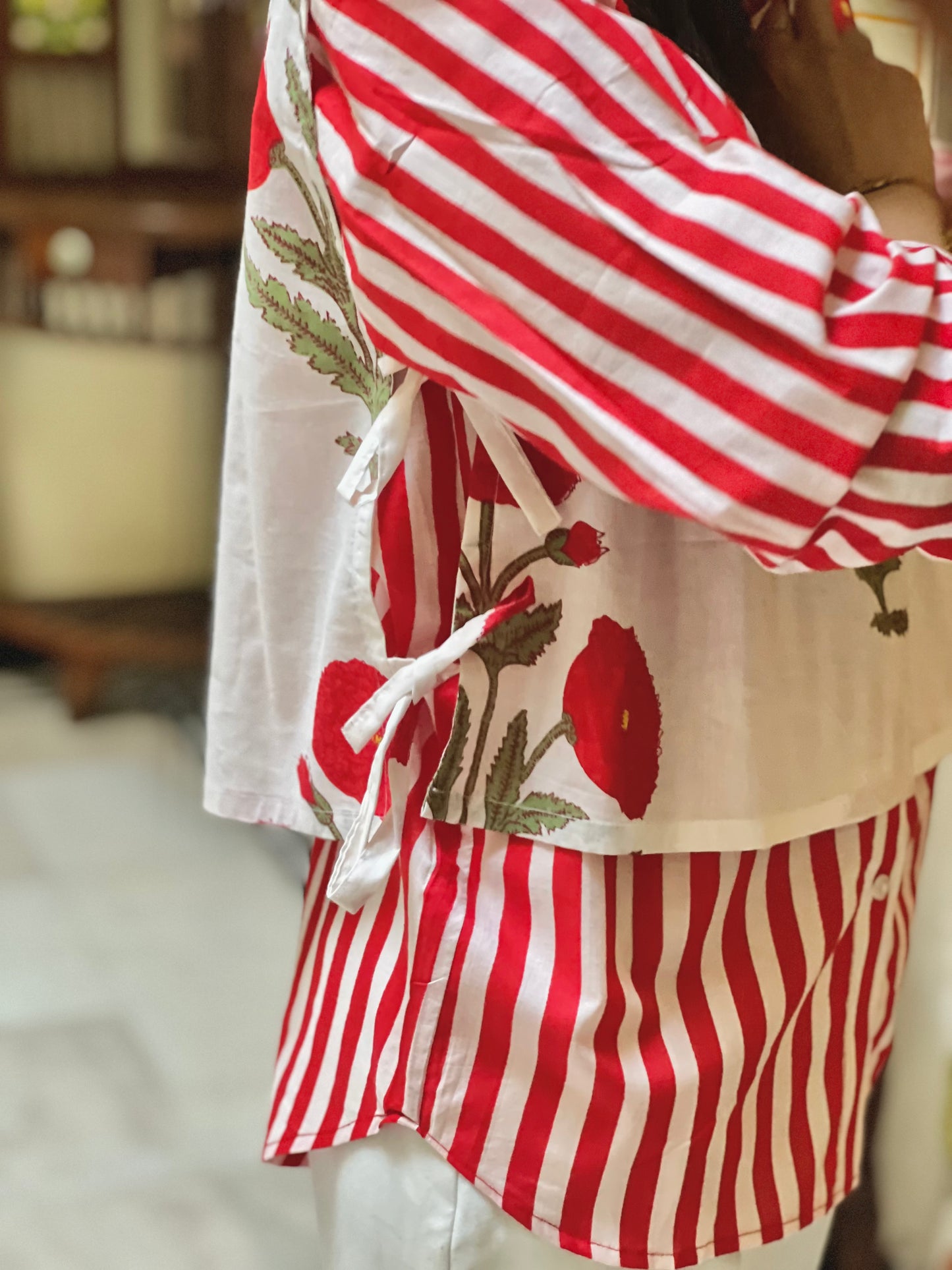 Red and white striped outfit with floral patterns on a blurred background