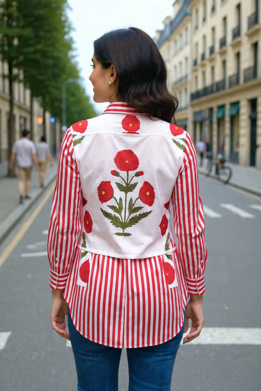 Woman wearing a red and white floral patterned shirt on a city street.