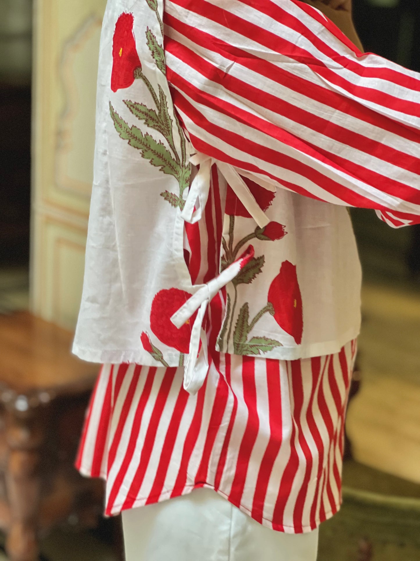 Red and white striped shirt with floral design on a blurred background