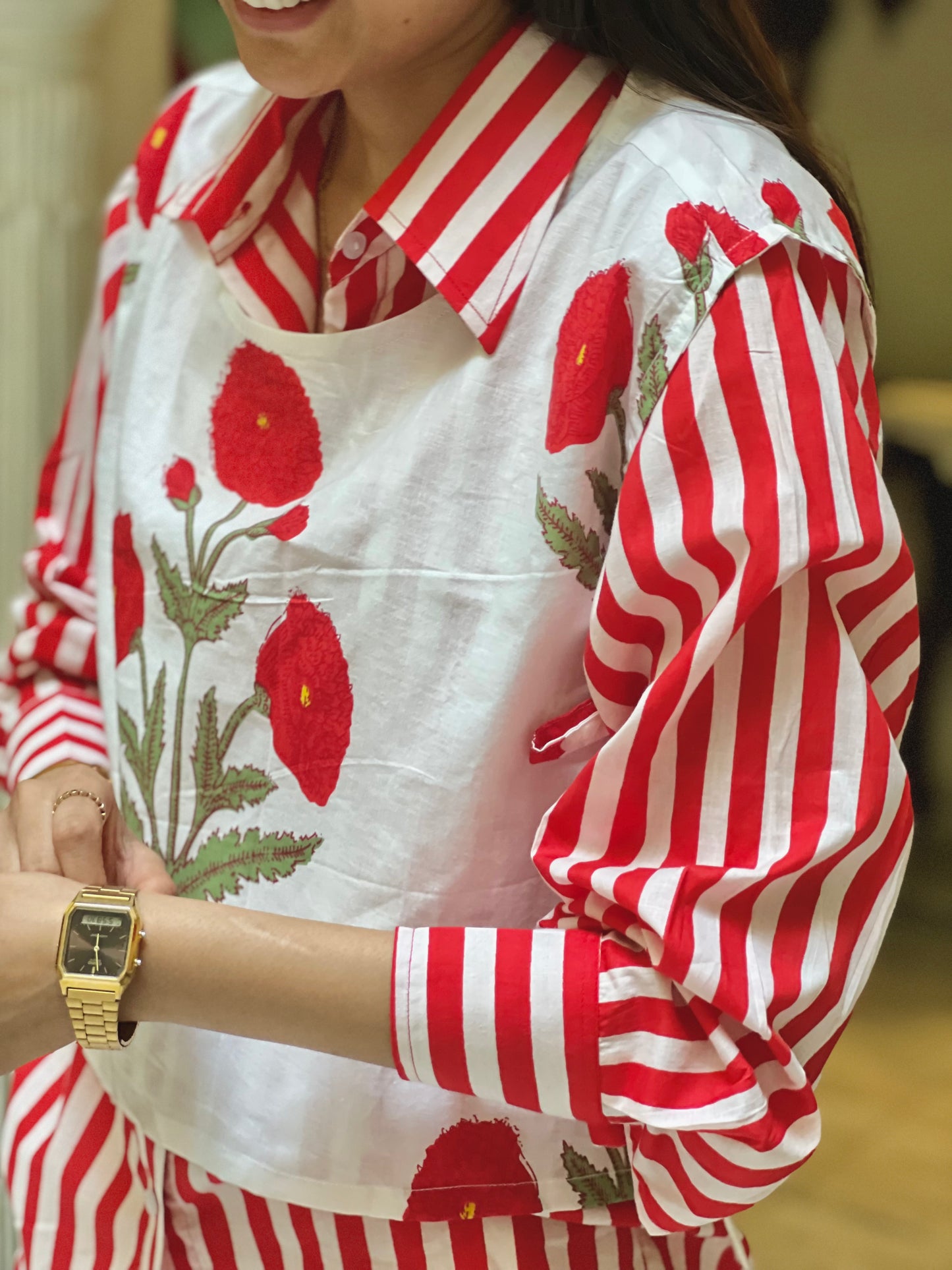 Person wearing a red and white striped shirt with floral patterns.
