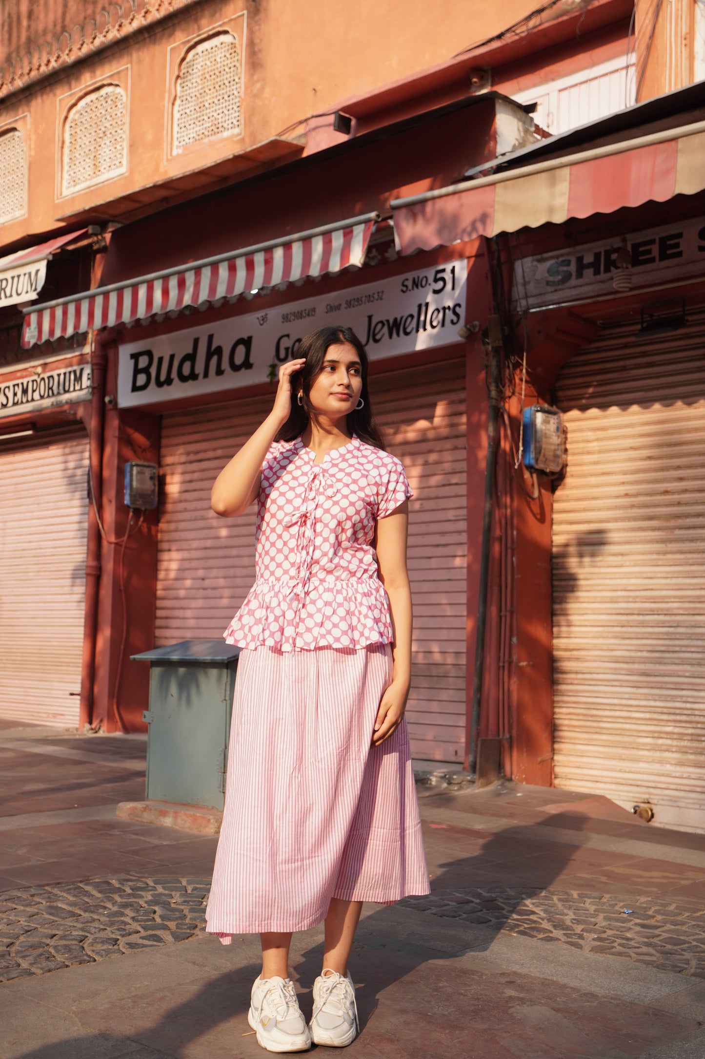 Woman in a pink outfit standing in Jaipur.