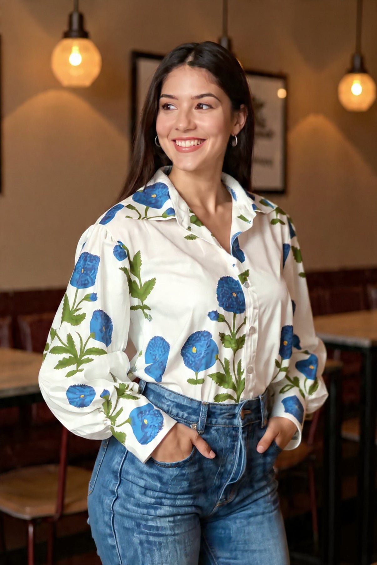 Woman wearing a white floral blouse with blue flowers in a restaurant setting