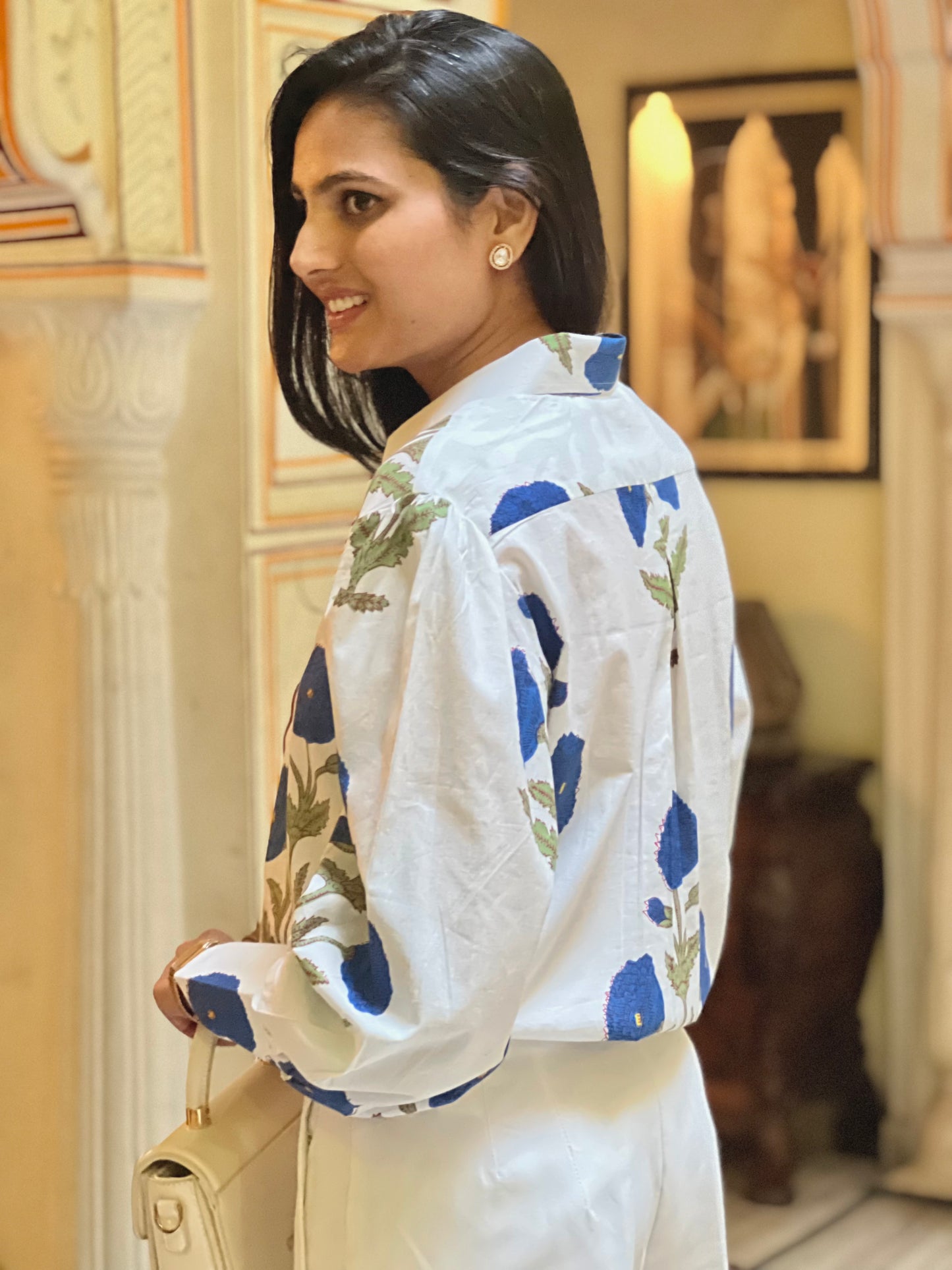 Woman wearing a white floral jacket in an indoor setting