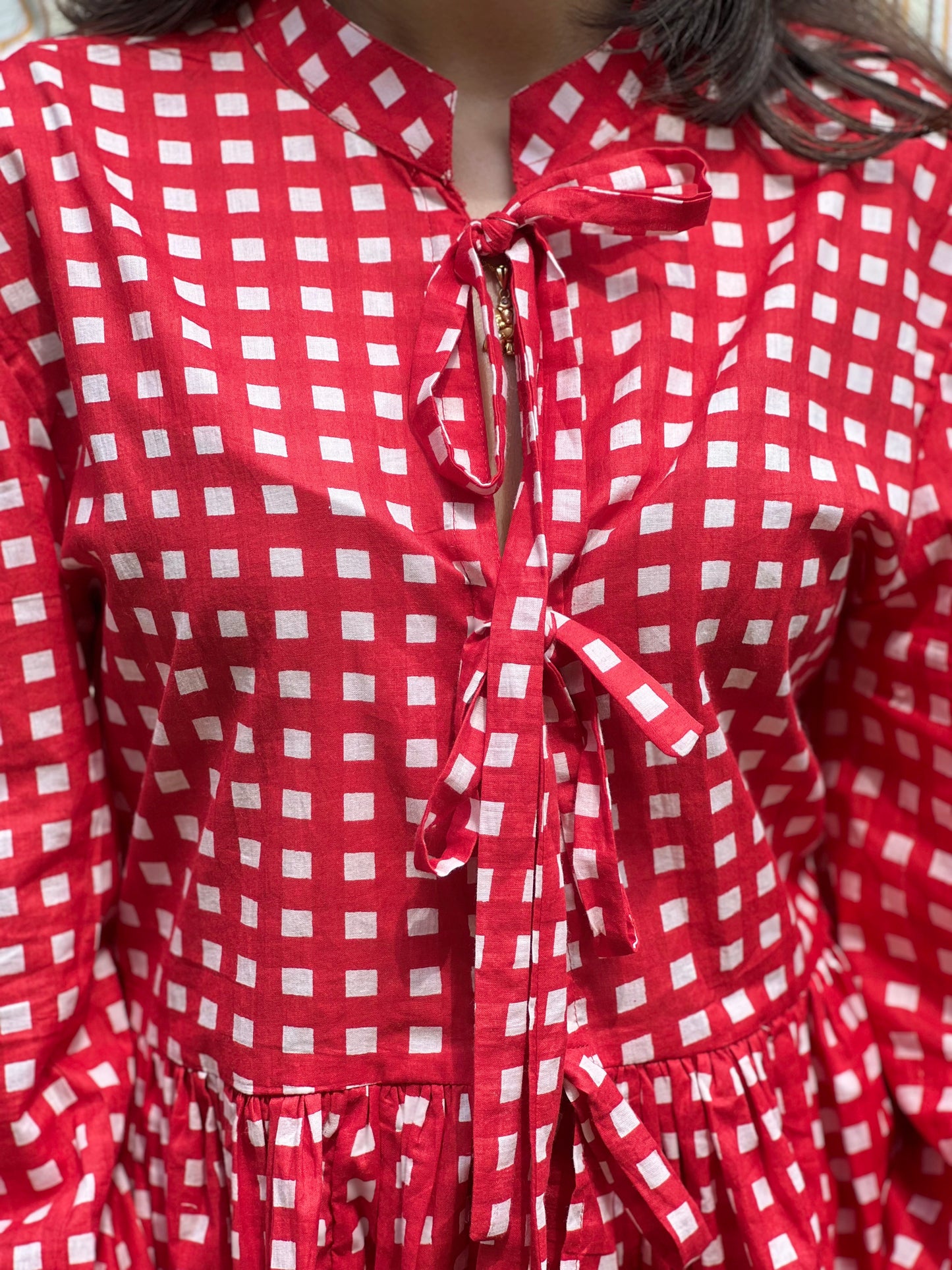 Red and white checkered dress with a bow detail on a person