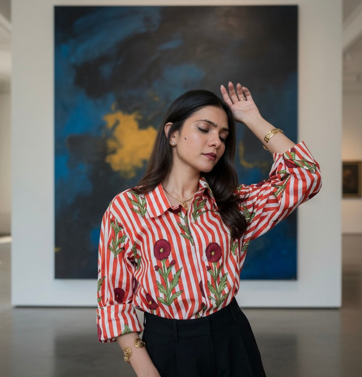 Woman wearing a red and white striped shirt with floral patterns in an art gallery.